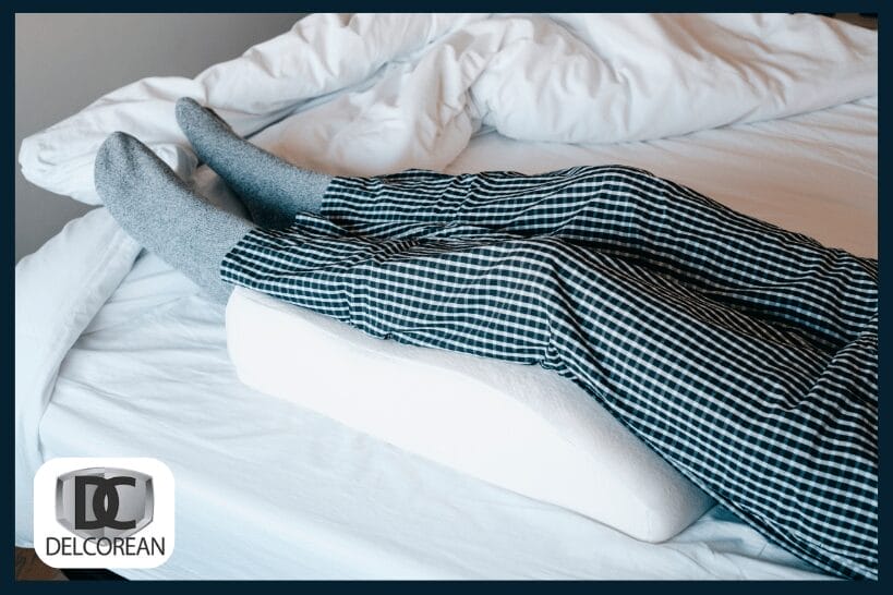 Legs elevated on pillow in bed to improve circulation and reduce cramps