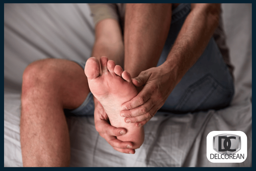 Man holding foot in bed due to nighttime foot cramp