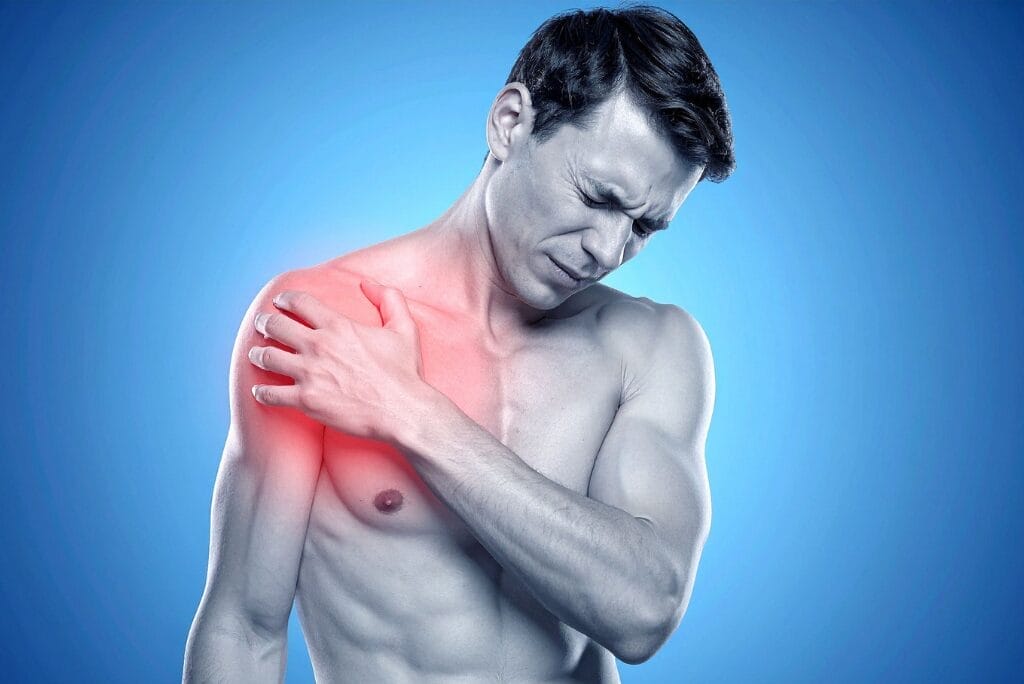 Man experiencing shoulder muscle pain, holding inflamed shoulder area illustrating common muscle soreness and recovery challenges
